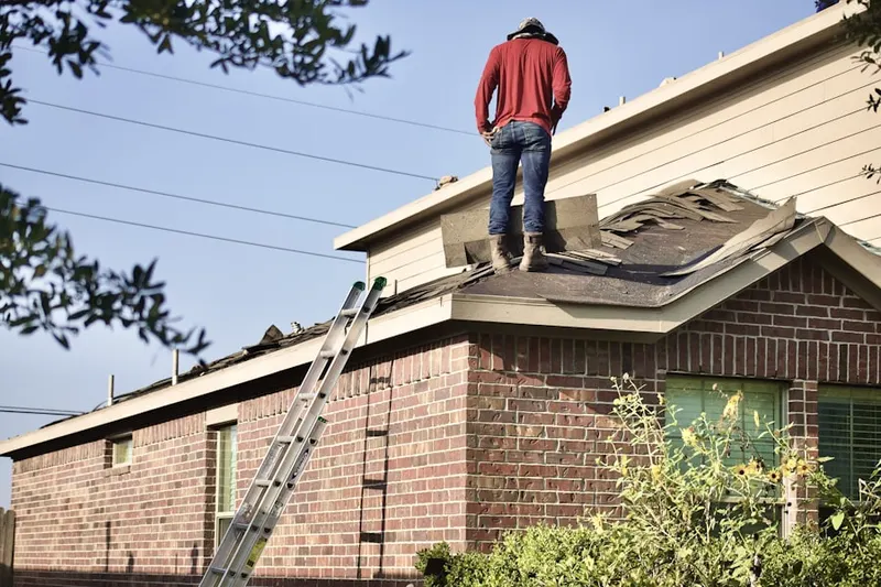 Professional roofer working on a residential roof in Round Knob